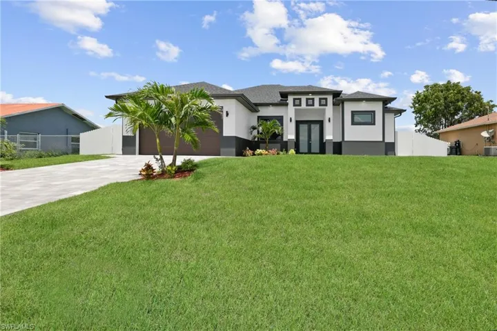 View of front of house featuring a front lawn and a garage