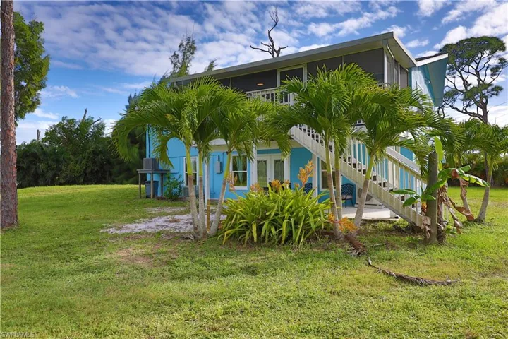 Back of house featuring a yard and stairs