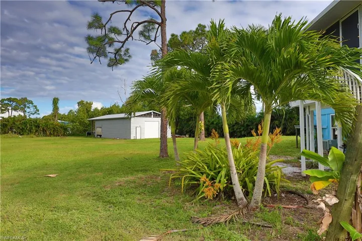 View of green lawn featuring an outdoor structure