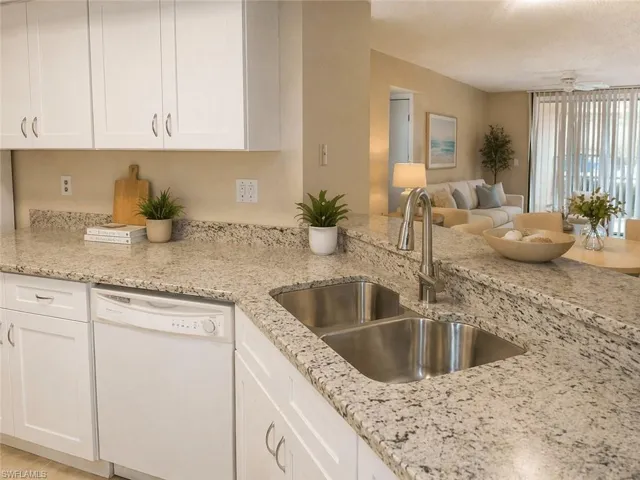 Kitchen featuring white shaker-style cabinetry, light granite countertops, and a double basin stainless steel sink with a gooseneck faucet #5.1