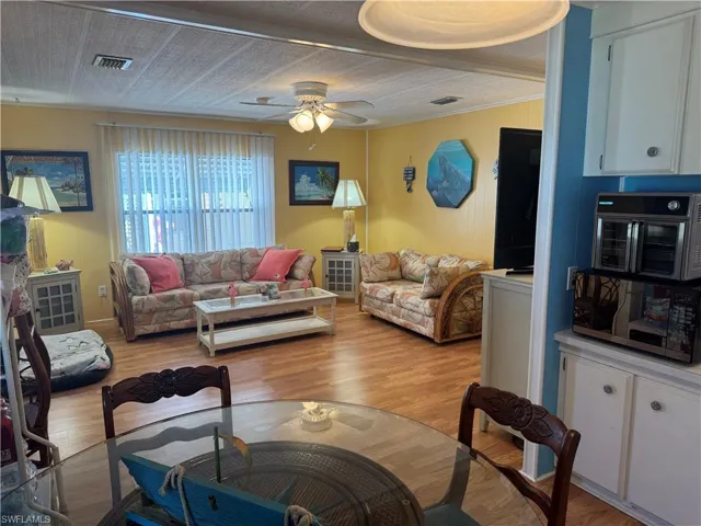 Living area with light wood-type flooring and a ceiling fan