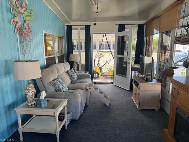 Living room featuring dark colored carpet and healthy amount of natural light