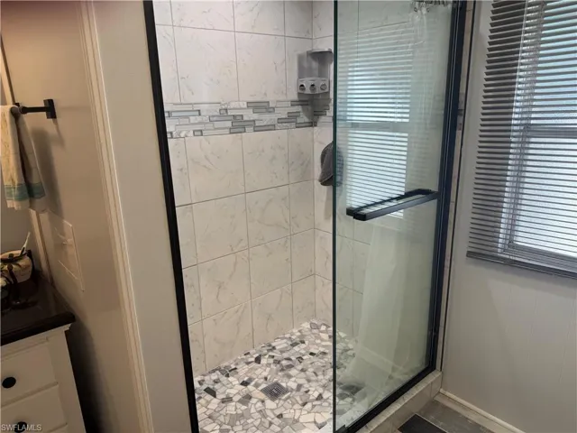 Bathroom featuring a shower stall and vanity