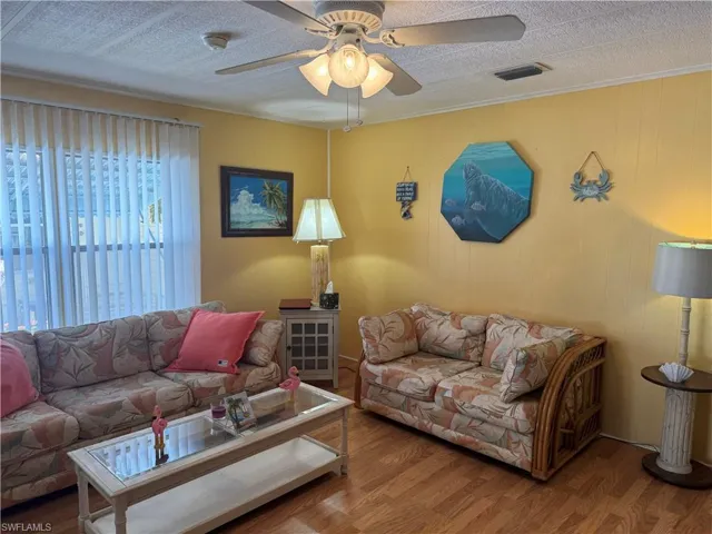 Living room featuring ceiling fan and wood finished floors