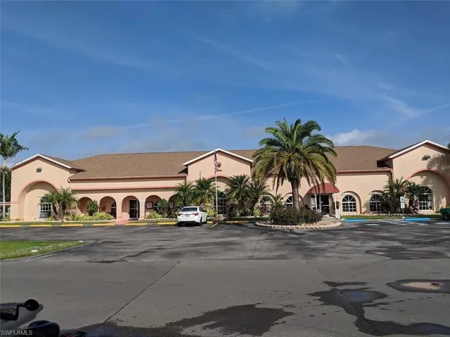 View of building exterior with uncovered parking