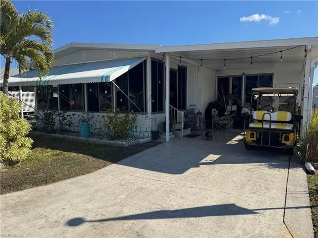 Rear view of property with a patio, a sunroom, and driveway