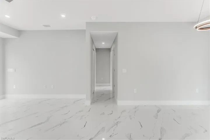 Unfurnished room with marble finish flooring and recessed lighting