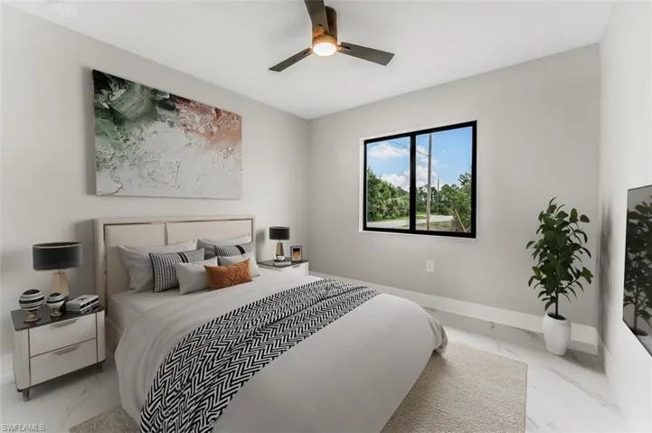 Bedroom staged with light marble finish floors and ceiling fan