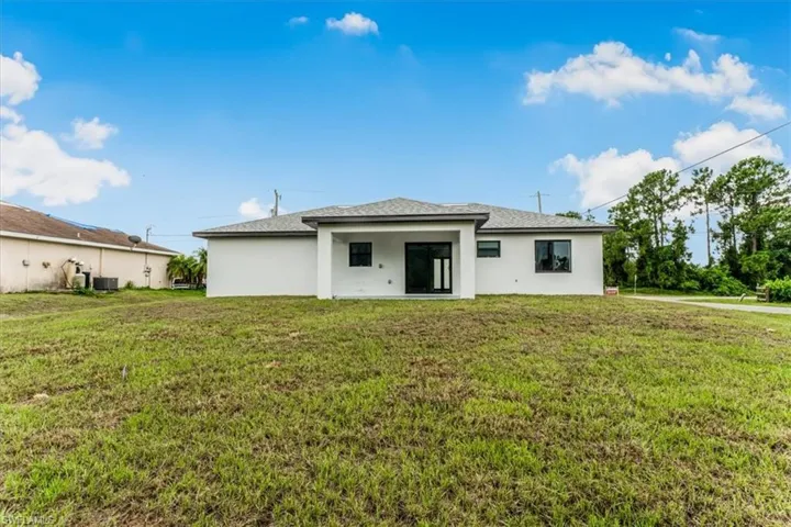 Back of property featuring stucco siding and a yard