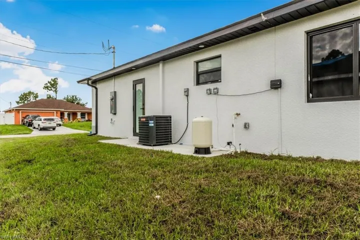 View of home's exterior with stucco siding and a lawn