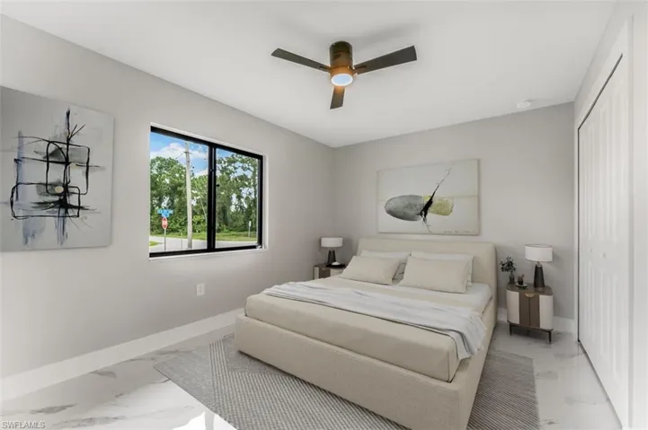 Bedroom staged featuring light marble finish floors, a closet, and ceiling fan