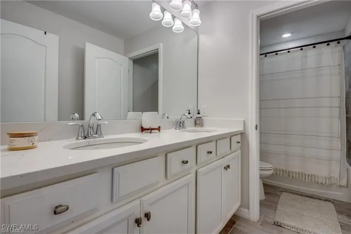 Bathroom with double vanity, shower / tub combo