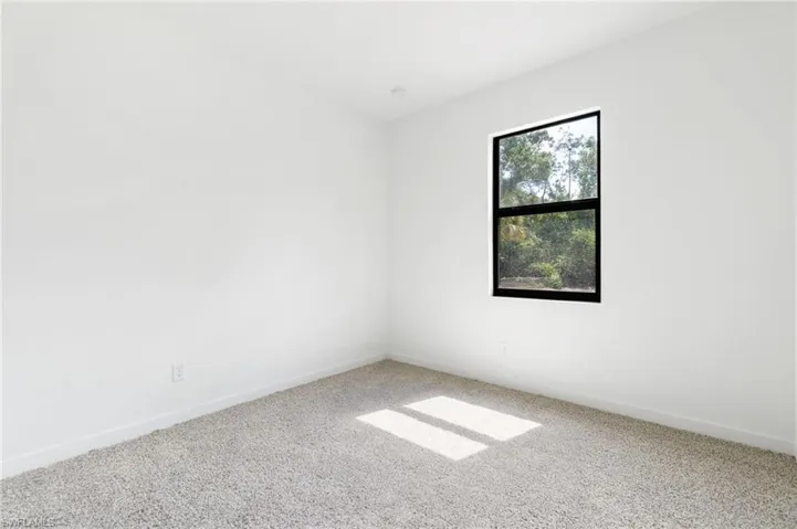 Carpeted empty room featuring baseboards