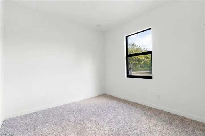 Carpeted spare room with baseboards