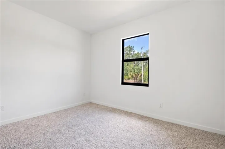 Unfurnished room featuring baseboards and carpet