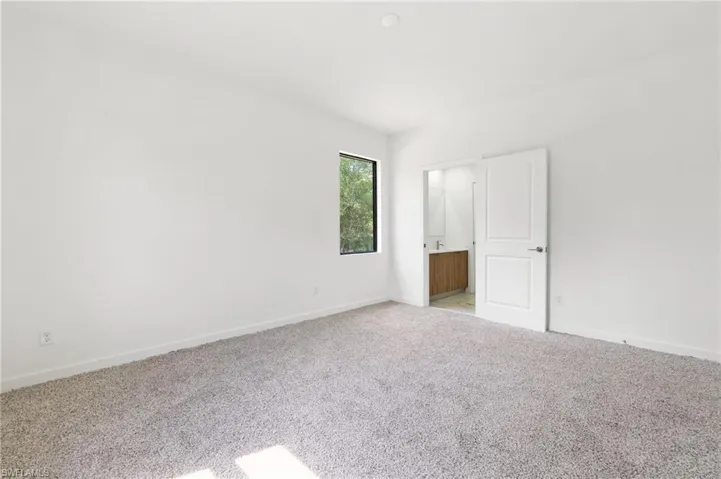 Empty room with baseboards and carpet
