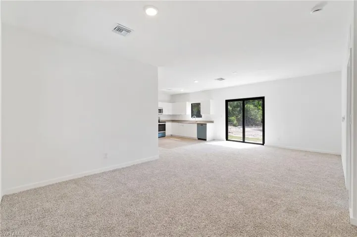 Unfurnished living room with baseboards, light carpet, recessed lighting, and visible vents