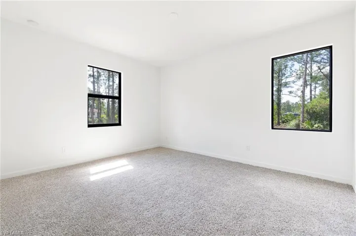 Carpeted empty room featuring baseboards