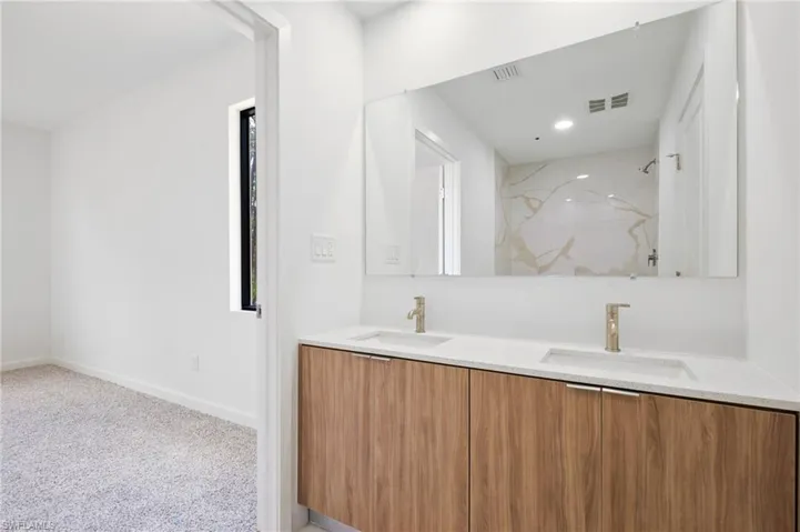 Full bathroom with a sink, a marble finish shower, baseboards, and visible vents