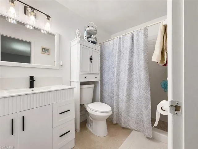Bathroom featuring a white vanity with fluted detailing, a rectangular integrated sink, and a matte black faucet