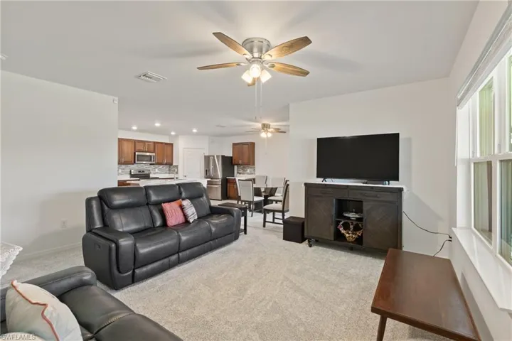 Living room featuring light carpet and ceiling fan