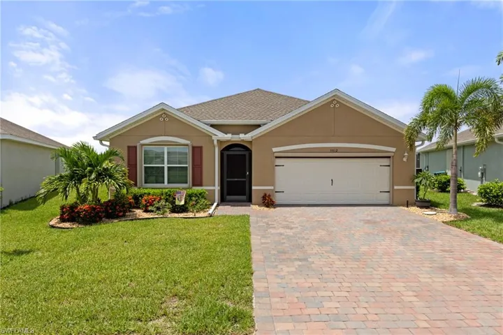 Ranch-style house with a garage and a front lawn