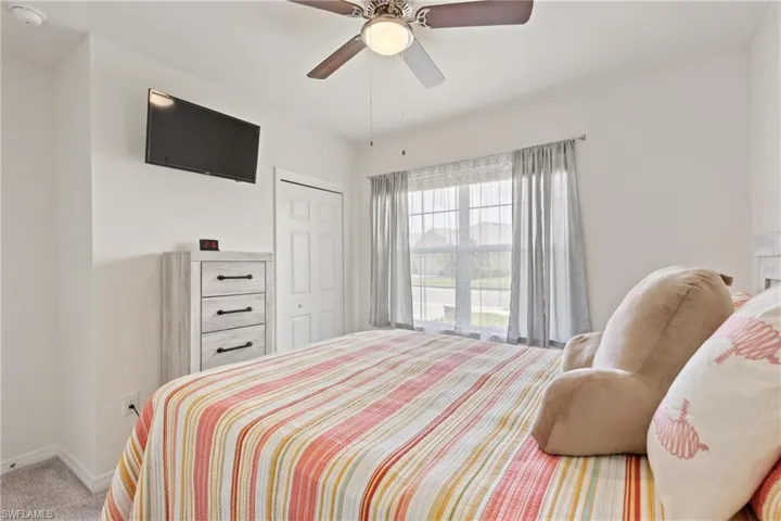 Carpeted bedroom featuring a closet and ceiling fan