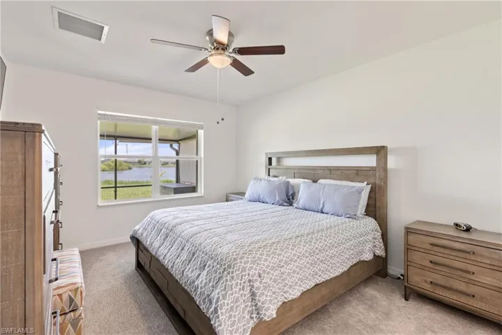 Carpeted bedroom featuring ceiling fan