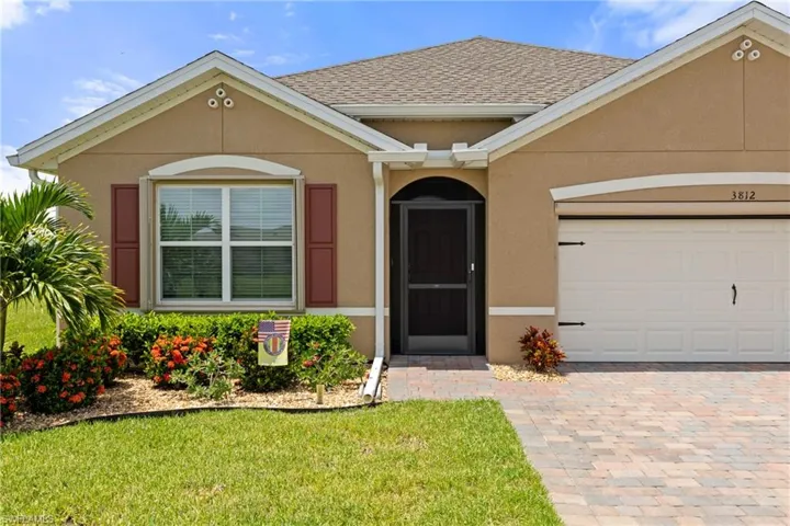 Ranch-style house with a front yard and a garage