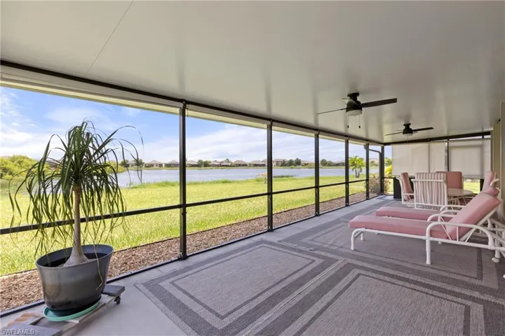 Unfurnished sunroom featuring ceiling fan, a wealth of natural light, and a water view