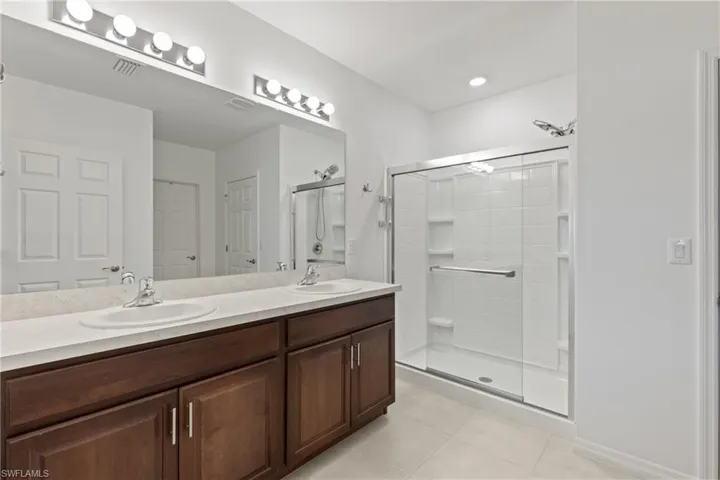 Full bathroom featuring shower / bath combo with shower curtain, vanity, tile patterned flooring, and toilet
