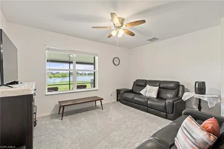 Living room with light carpet and ceiling fan