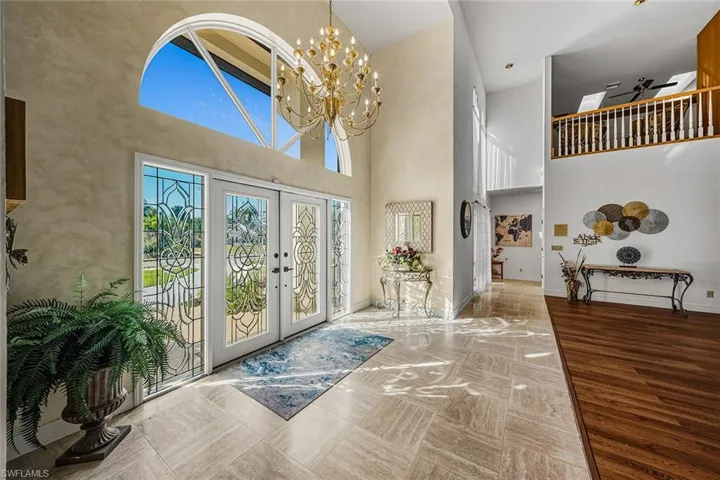 Foyer with french doors, a high ceiling, and a chandelier