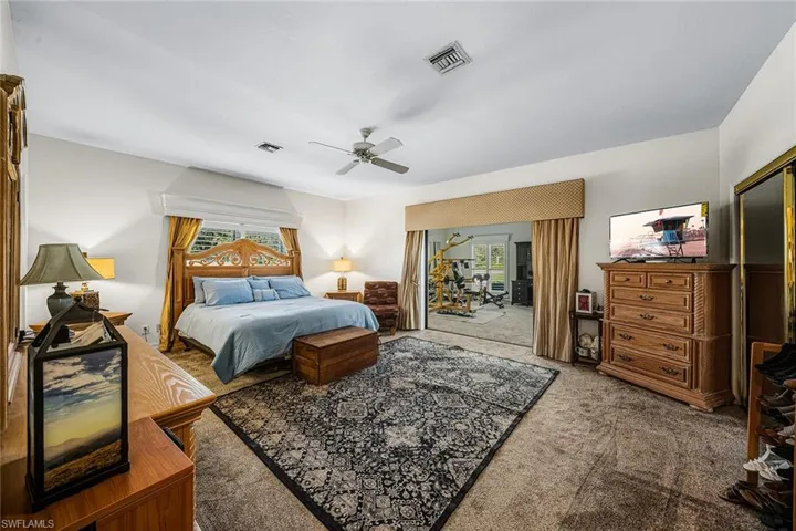 Carpeted bedroom with access to exterior, ceiling fan, and a closet