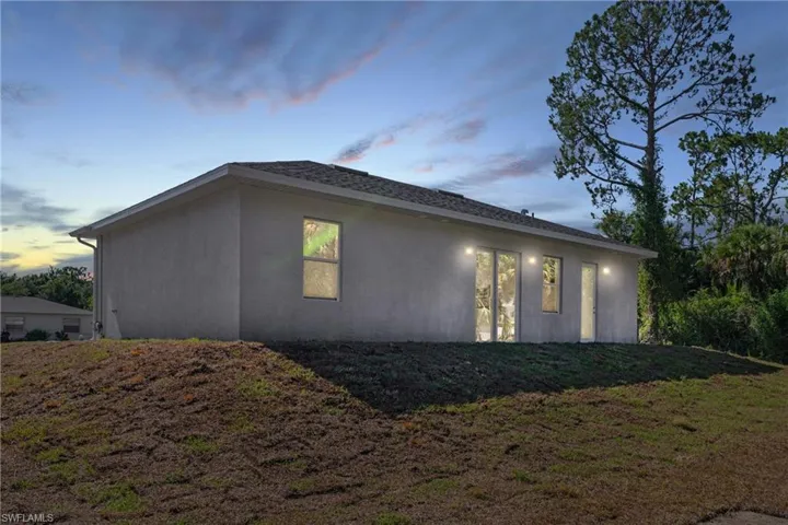 Property exterior at dusk featuring a yard