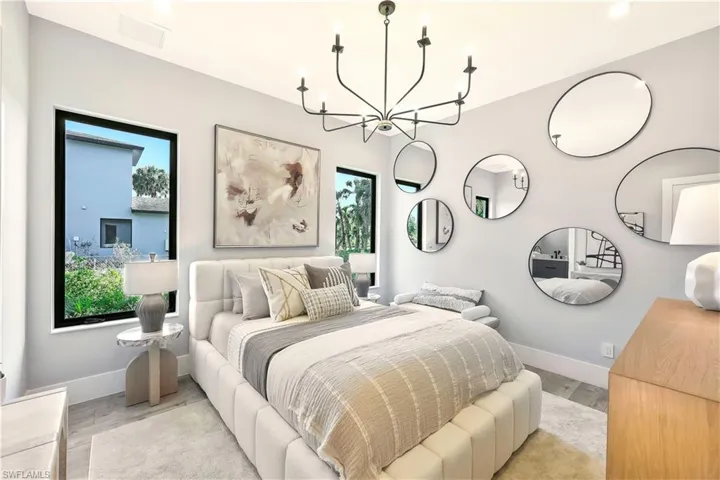 Bedroom with suspended lighting and wood finished floors