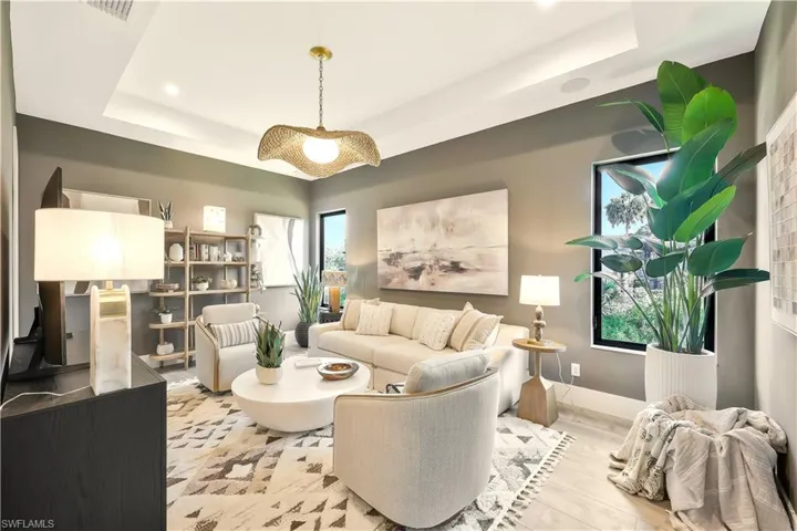 Living room with a tray ceiling, wood finished floors, and recessed lighting