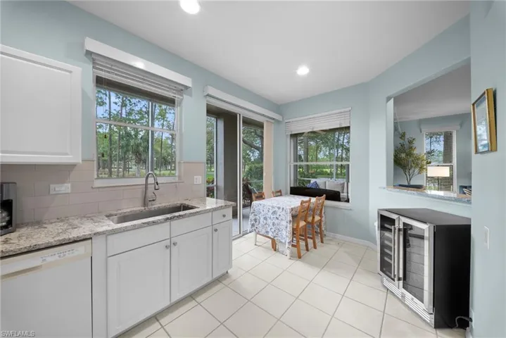 Kitchen with dishwasher, light stone counters, white cabinetry, tasteful backsplash, and recessed lighting