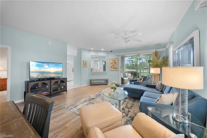 Living room with a ceiling fan, light wood-style floors, and recessed lighting
