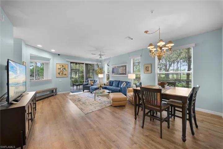 Dining area featuring ceiling fan, hanging lights, and light wood-style flooring