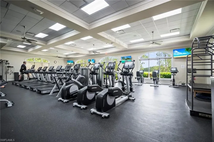 Exercise room with a ceiling fan and a paneled ceiling