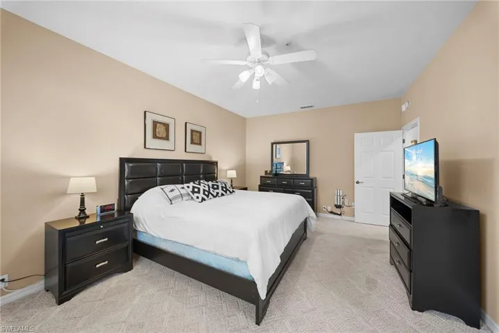 Bedroom with light carpet and a ceiling fan