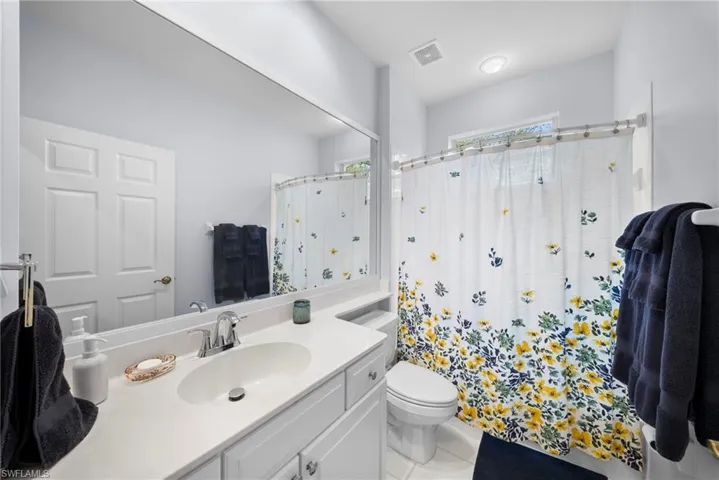 Bathroom featuring vanity, curtained shower, and light tile patterned floors
