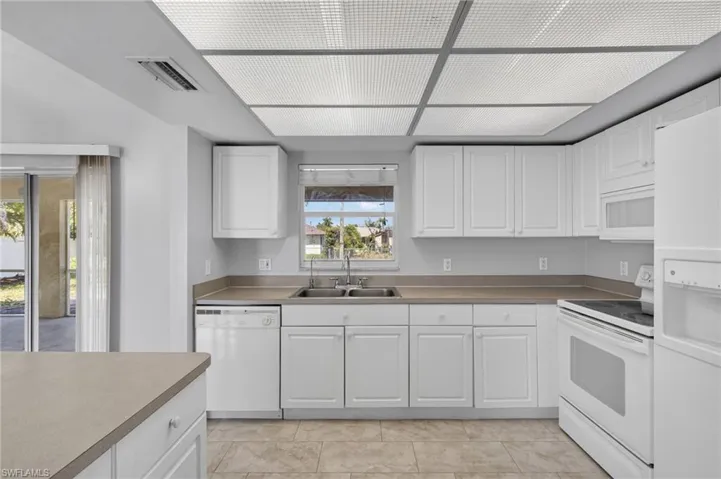 Kitchen with white appliances and white cabinetry