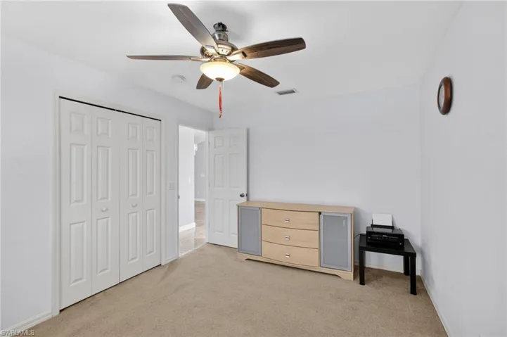Unfurnished bedroom featuring light colored carpet, ceiling fan, and a closet