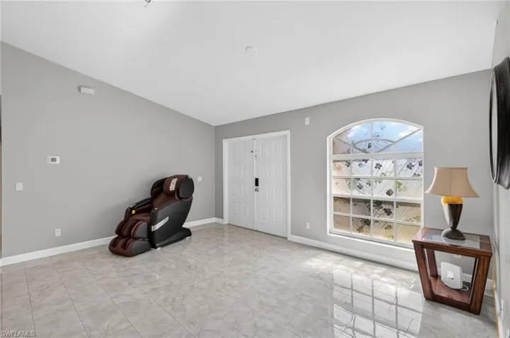 Unfurnished room featuring baseboards and lofted ceiling