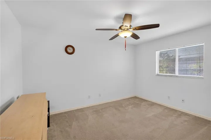 Unfurnished room featuring light carpet and ceiling fan