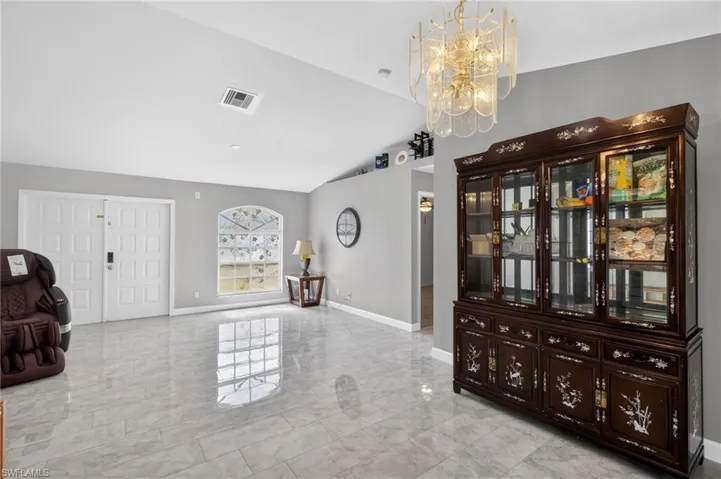 Unfurnished room featuring a chandelier and lofted ceiling