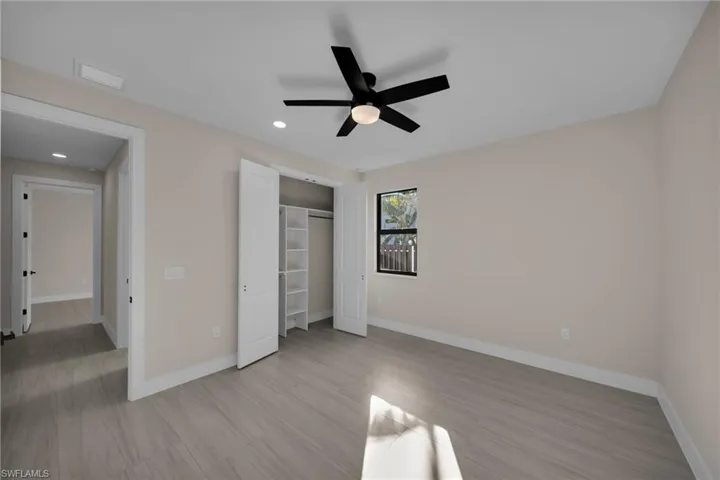 Unfurnished bedroom featuring a ceiling fan, a closet, light wood finished floors, and recessed lighting