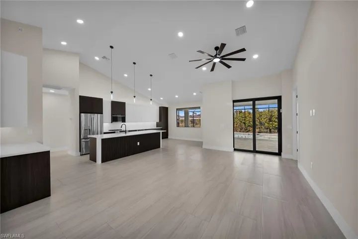 Unfurnished living room featuring a ceiling fan, recessed lighting, and lofted ceiling